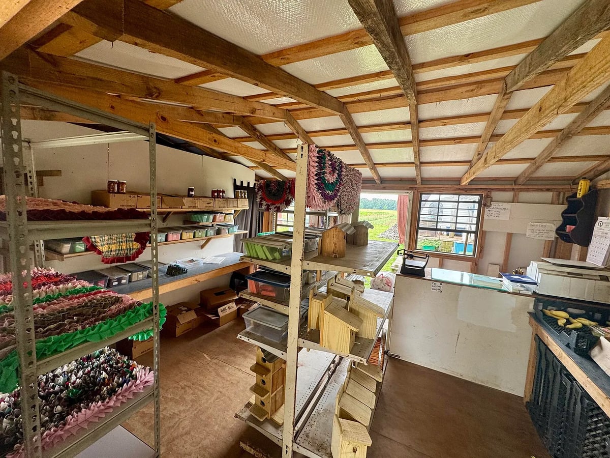 Rag rugs, wooden birdhouses, and jarred goods on shelves inside an Amish shop in Randolph, Mississippi