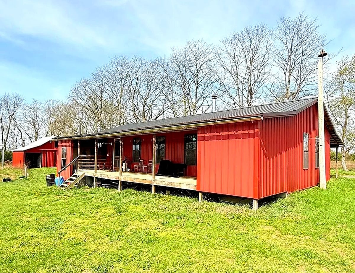 Amish home in Cynthiana, Kentucky — red metal siding, covered front porch, and barn visible at left