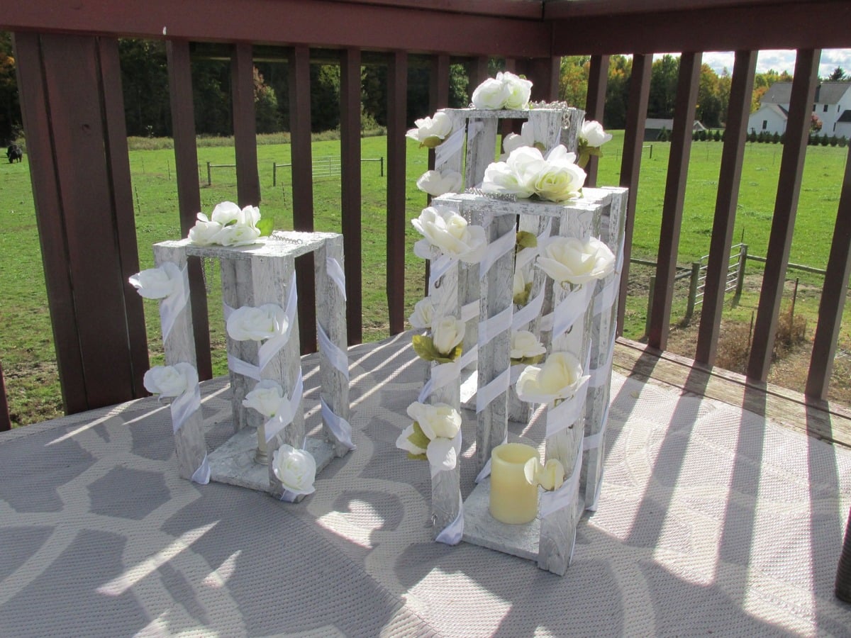 Decorated wooden stands with white roses and ribbon for an Amish wedding