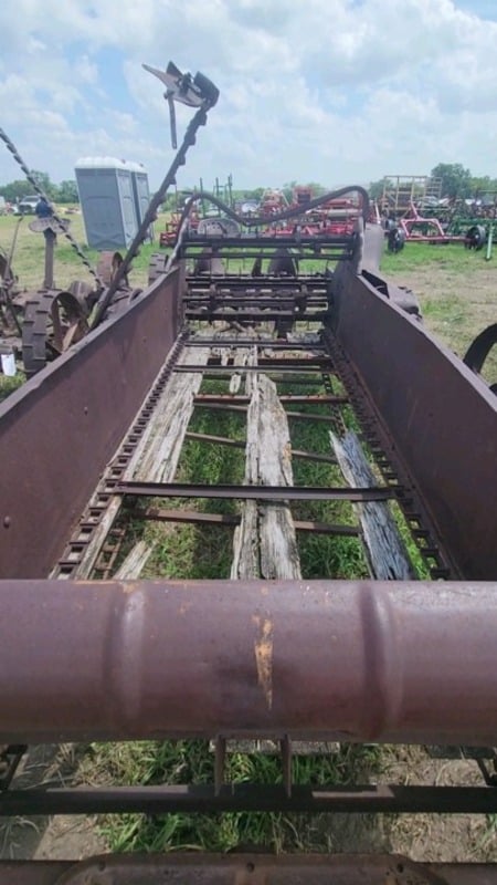Rotted wooden floor and chain drive inside an old manure spreader