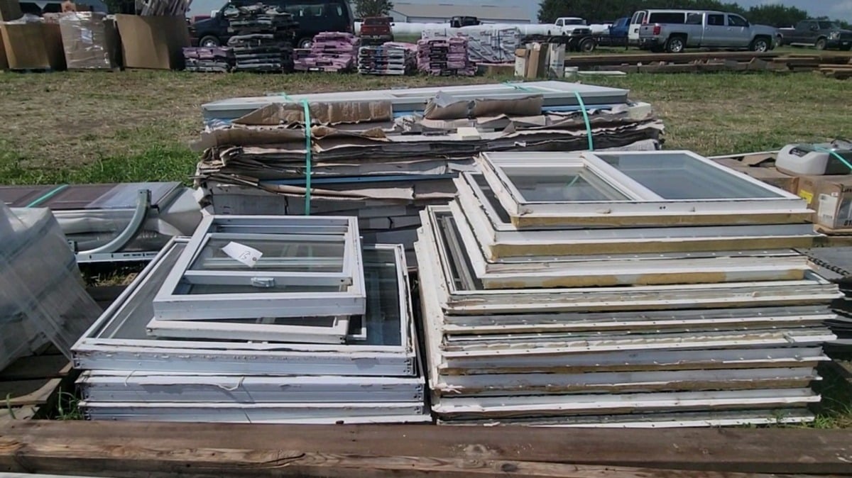 Stacks of used windows of different shapes and sizes at the auction