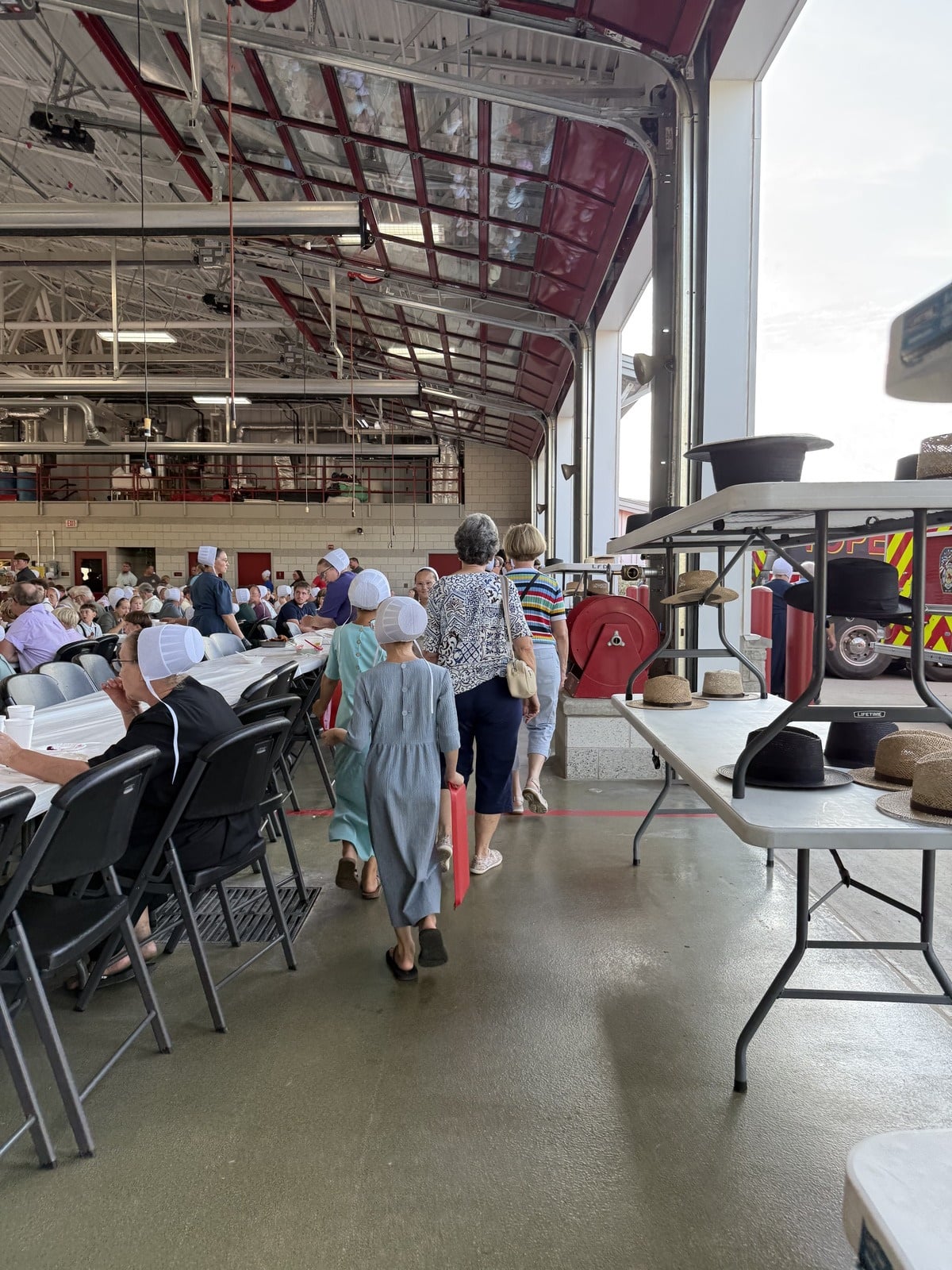 Amish girls walking down an aisle between tables at the Topeka fish fry