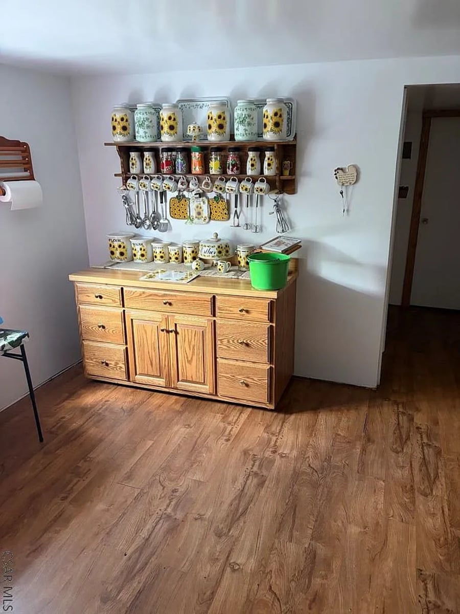 Sunflower-themed canisters and mugs on a hutch in an Amish kitchen