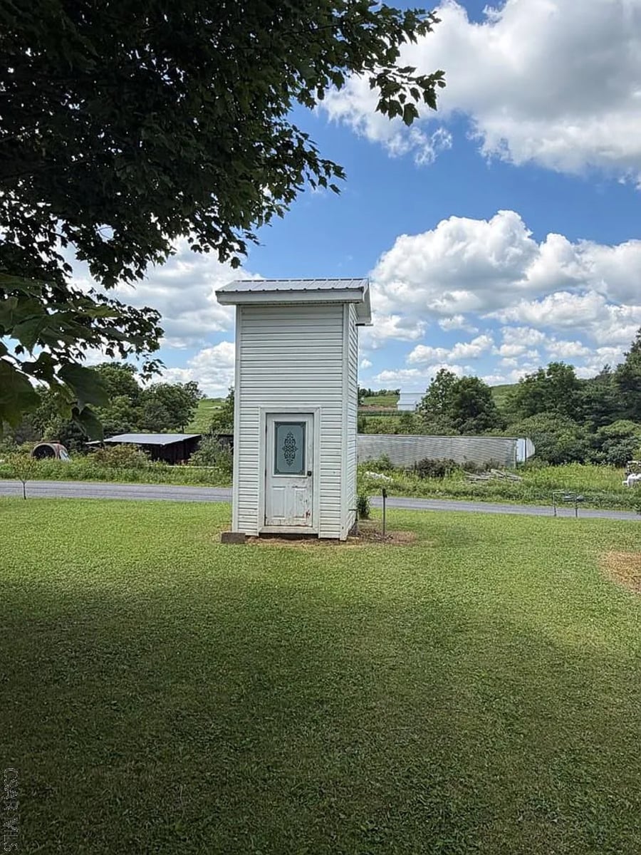 Tall narrow white outbuilding near the road on an Amish property in Punxsutawney, Pennsylvania