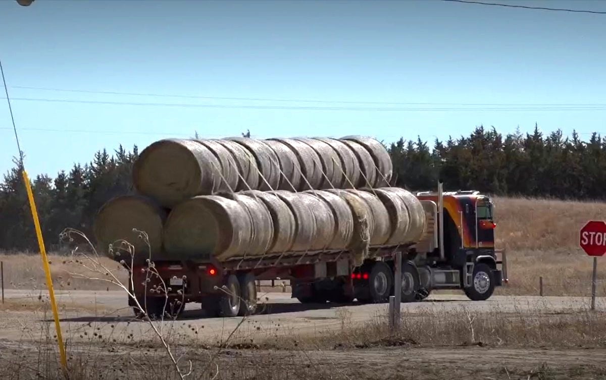  Truck loaded with round hay bales on a rural Nebraska road heading to deliver donated hay to an Amish family after the Anderson Bridge Fire