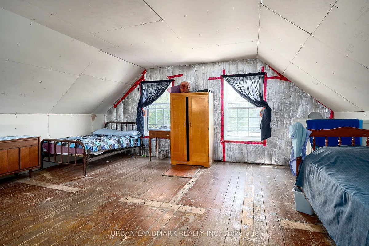 Upstairs bedroom in an Amish home near Stirling, Ontario Upstairs Amish bedroom with foil insulation walls, slanted ceiling and plank floor in Ontario