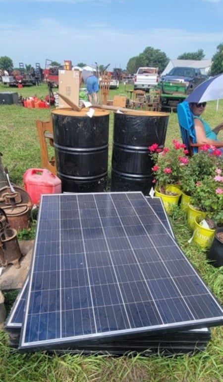 Used solar panels stacked on the ground at the Amish auction