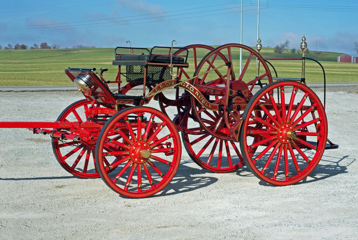 Restored Cooney hose cart in bright red with gold lettering and brass lamps