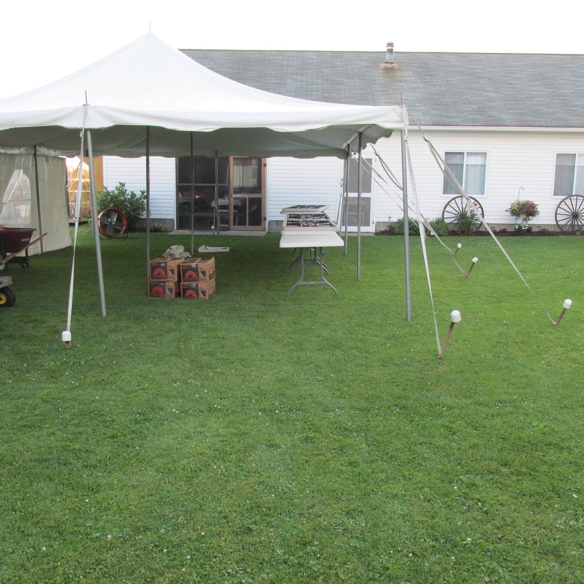 Tent set up beside an Amish home with boxes of Idaho potatoes underneath