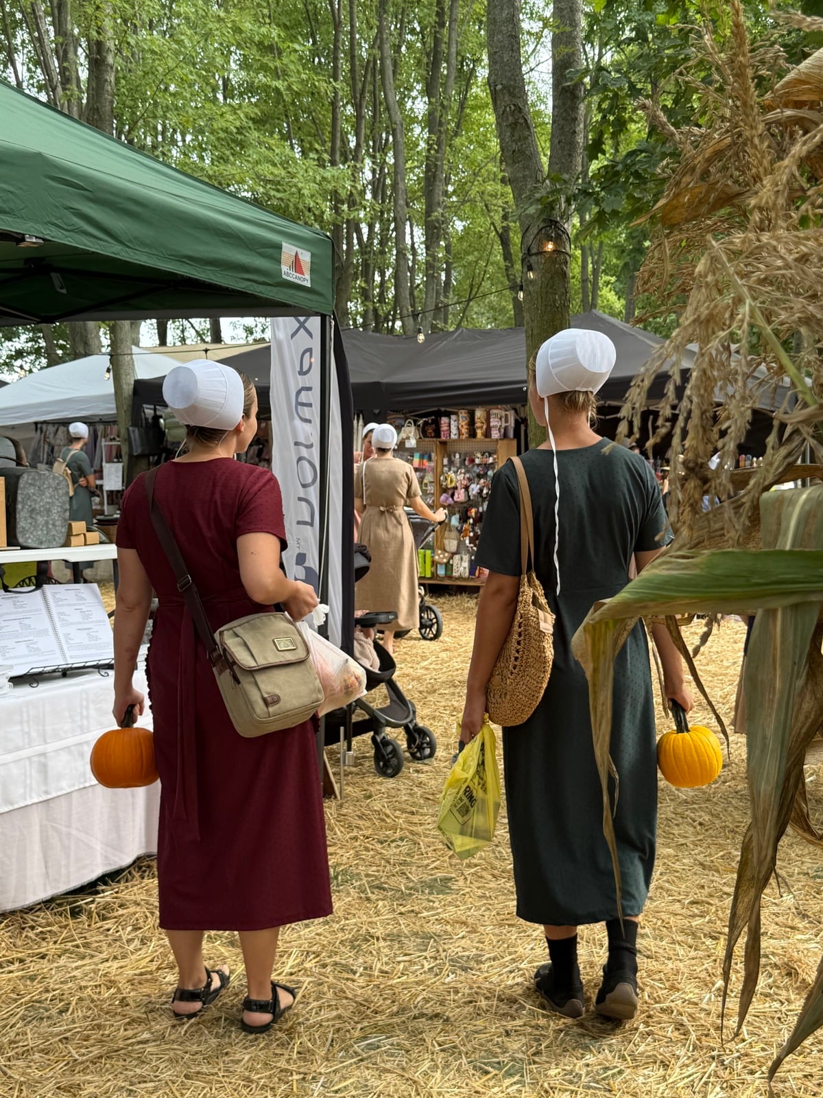 Two Amish women carry small pumpkins at Rentown Old Fashion Days