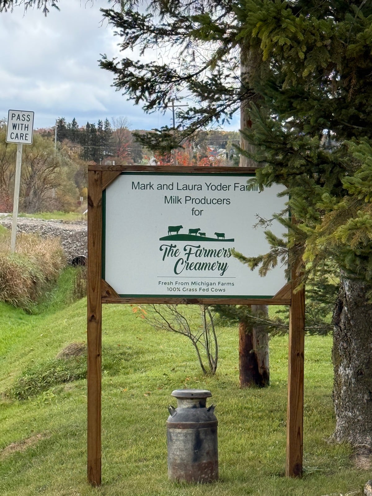 Sign reading "Mark and Laura Yoder Family, Milk Producers for The Farmers' Creamery" with a milk can beneath it